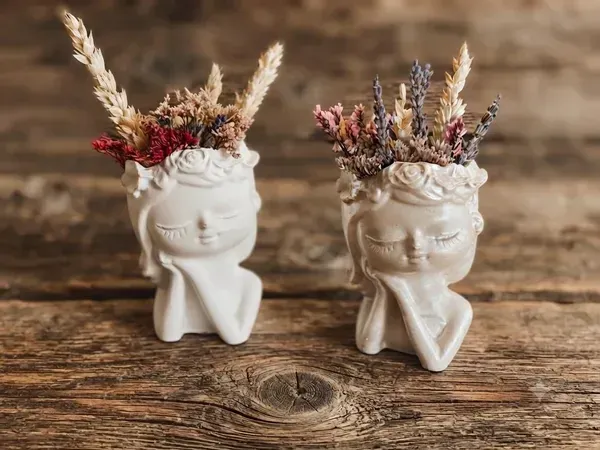 Figuras de yeso con forma de carita y flores secas naturales
