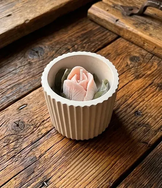 Vaso de yeso decorado con flor seca y vela de soja