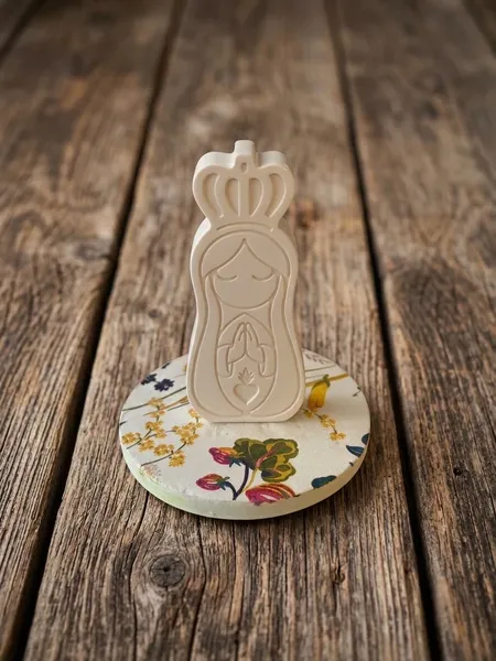 Figura de yeso de la Virgen estilo silueta minimalista sobre platito con tela floral